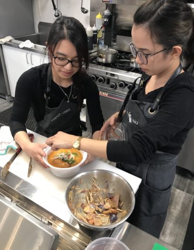 Trainees preparing a laksa soup by Expat Asia restaurant